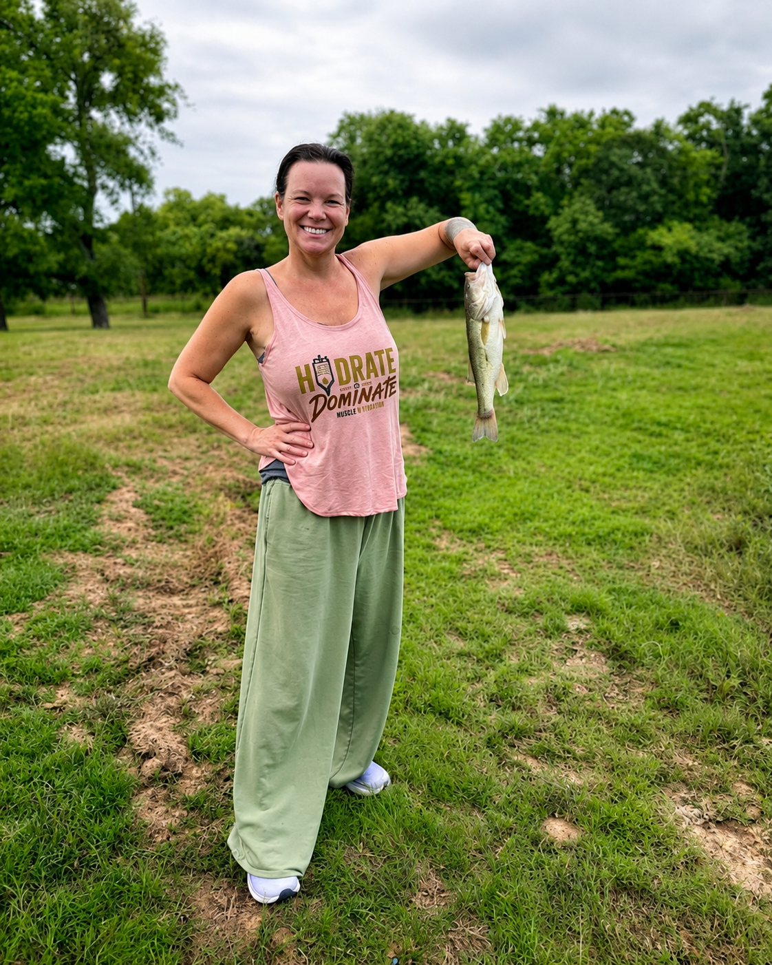 Tracy, RN and owner of Hydrate to Dominate Mobile IV Therapy, holding a fish outdoors